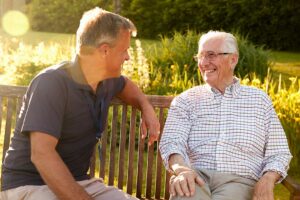 Older adult and family member reviewing assisted living information at a kitchen table.